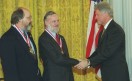 Ken Thompson (izq) y Dennis Ritchie (centro) recibiendo la Medalla Nacional de Tecnología en 1998 de manos del entonces presidente Bill Clinton (der). Fuente: Wikipedia